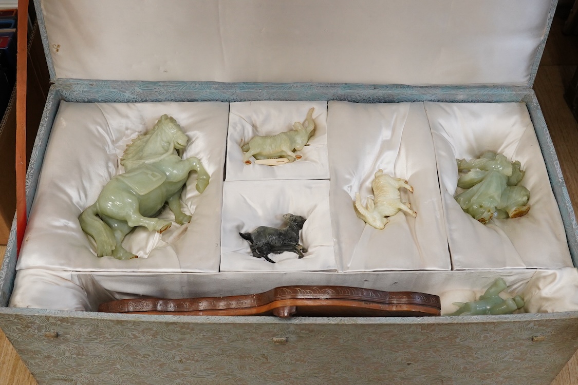 A Chinese silk brocade box containing six Chinese hard stone coloured carved animals and a wooden and metal inlaid stand, largest a horse 19cm wide